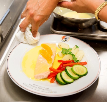 Person cleaning a dinner plate with food